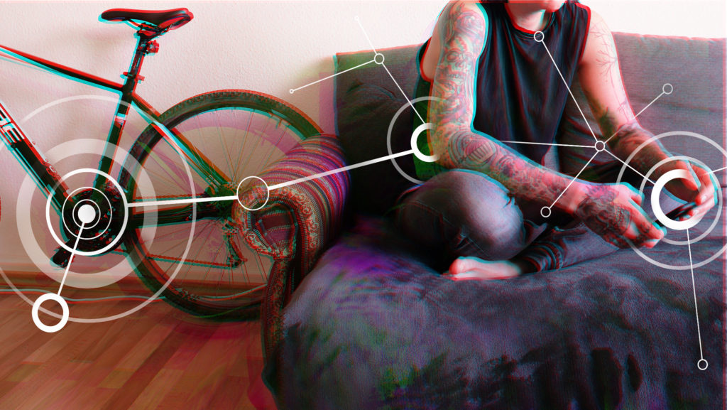Eine Person mit Tattoos an den Armen sitzt im Schneidersitz auf dem Sofa und hält ein Smartphone in der Hand. Über dem Foto liegt eine Grafik aus verbundenen Kreisen.